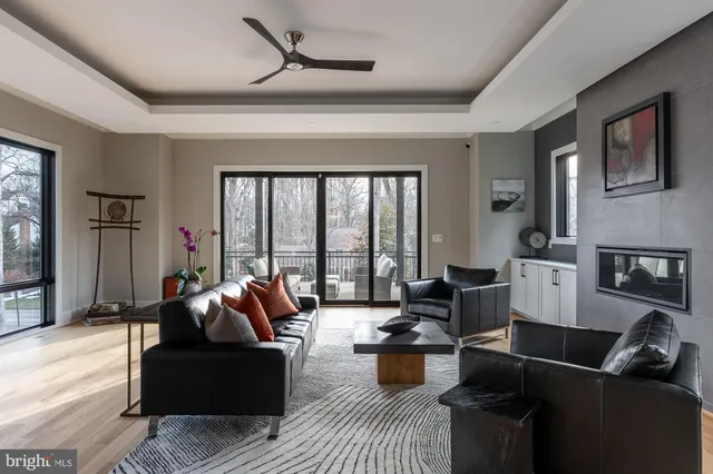 a spacious bedroom with a large bed a chandelier and windows