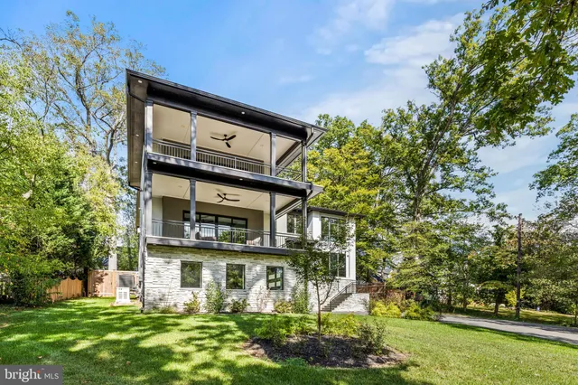 a view of a house with a big yard and large trees