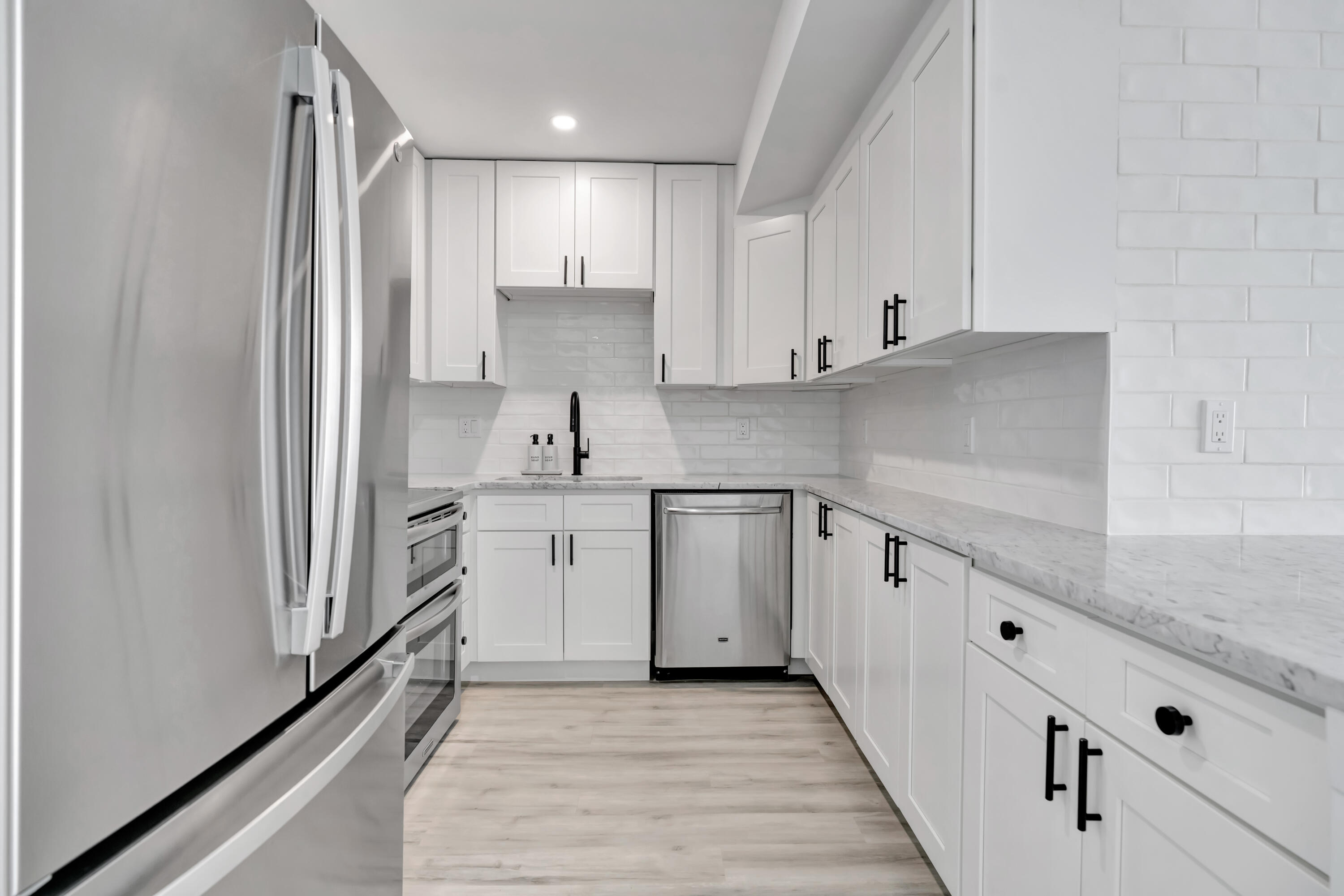 336 Golfview Road, Unit 1104 North Palm Beach, FL 33408 - Photo 6 of 54 a kitchen with granite countertop white cabinets and white appliances