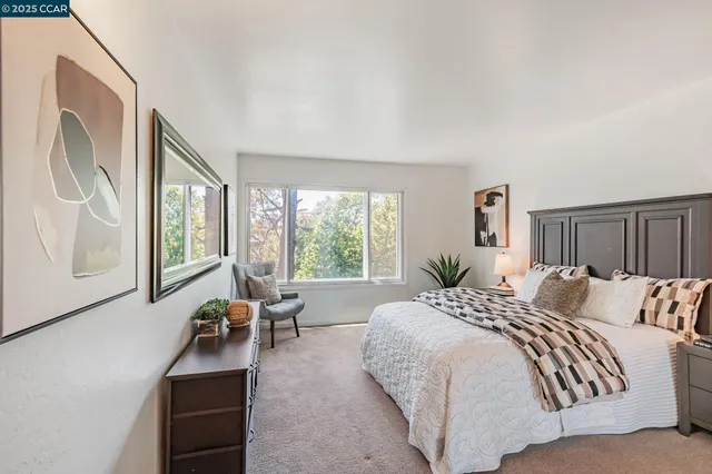 a bedroom with a large bed couch and a window