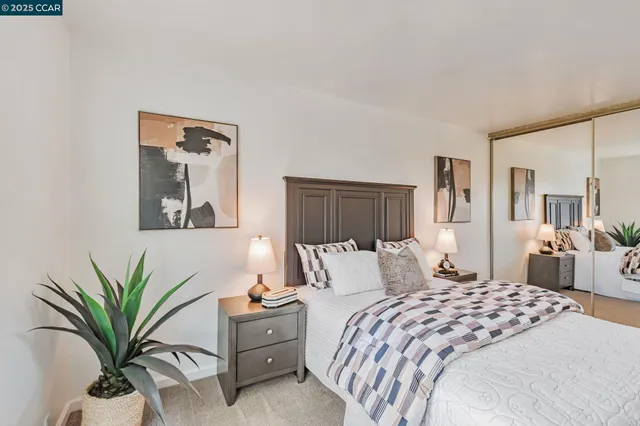 a bedroom with a large bed and a potted plant