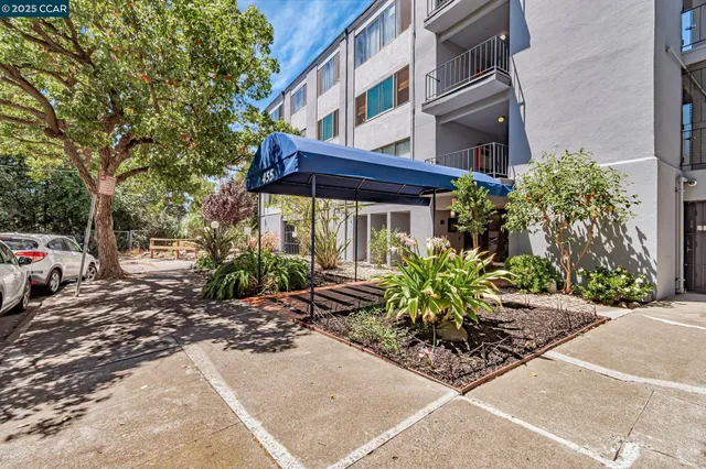 a view of a house with a small yard and potted plants