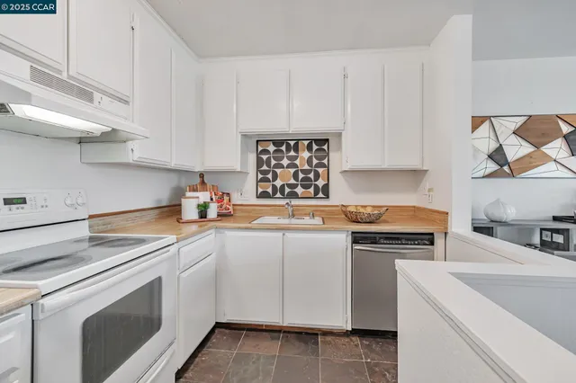 a kitchen with cabinets appliances a sink and a counter top