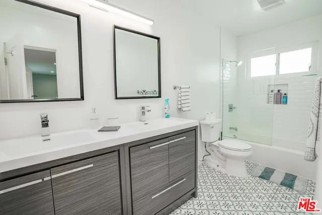 a bathroom with a double vanity sink toilet and shower