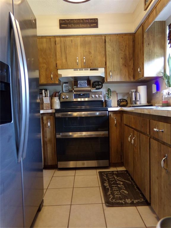 33068 Round Table Road Dade City, FL 33523 - Photo 56 of 82 a kitchen with stainless steel appliances granite countertop a stove a refrigerator and a sink