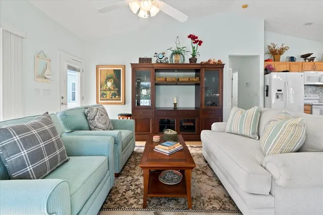 a living room with furniture a flat screen tv and a chandelier