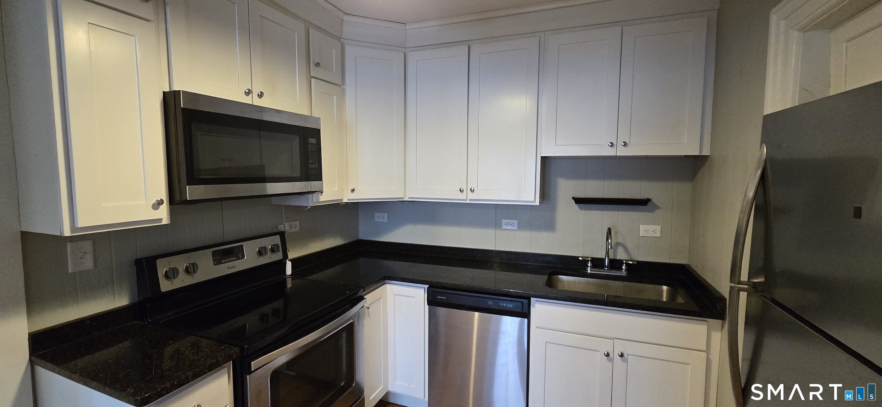 57 Broad Street, Unit 5 Norwich, CT 06360 - Photo 1 of 1 a kitchen with granite countertop white cabinets and refrigerator