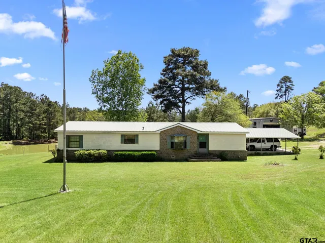 a swimming pool with yard in front of it