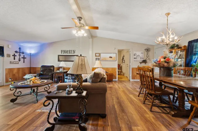 a living room with furniture a dining table and a chandelier