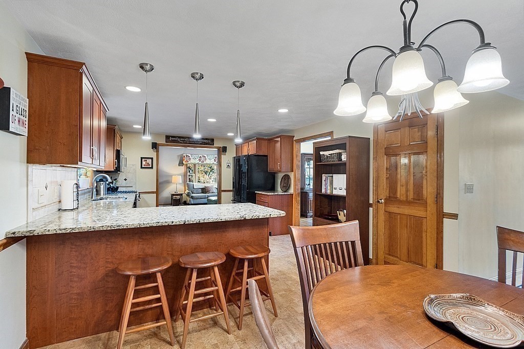 5 Abby Road Westford, MA 01886 - Photo 11 of 41 a kitchen with stainless steel appliances granite countertop a sink table and chairs