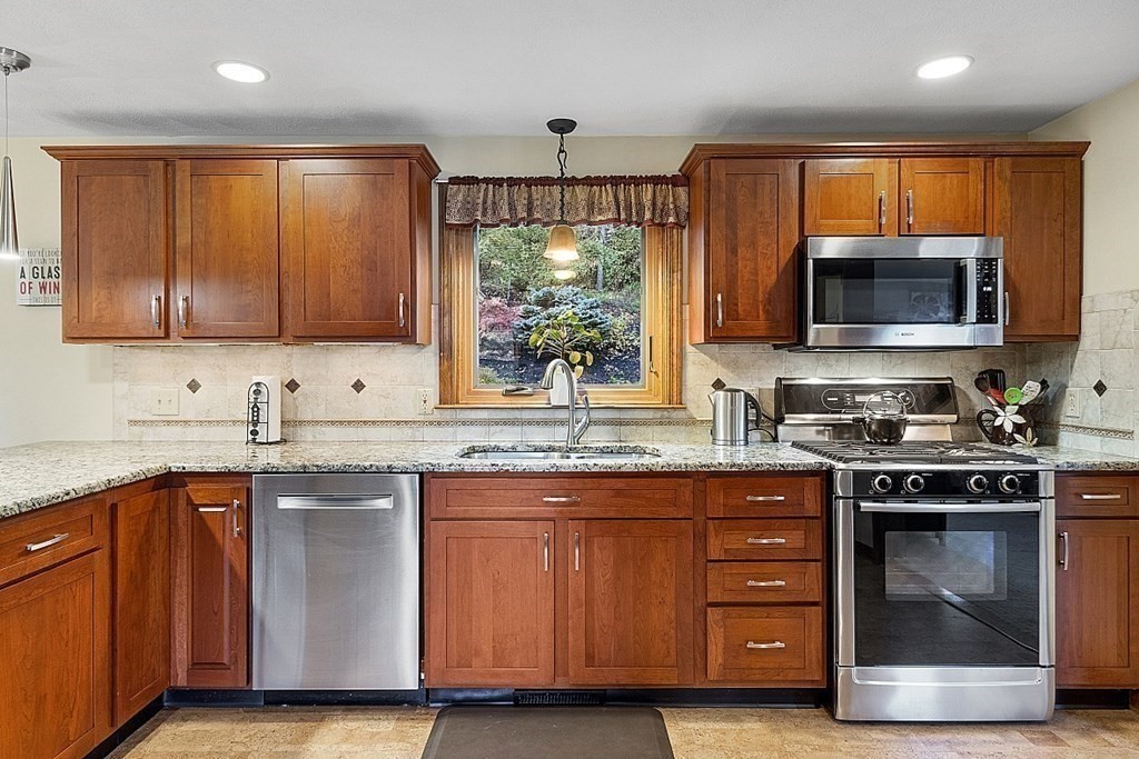 5 Abby Road Westford, MA 01886 - Photo 12 of 41 a kitchen with stainless steel appliances granite countertop a stove a sink and a microwave