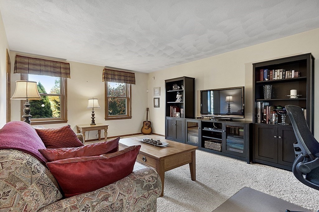 5 Abby Road Westford, MA 01886 - Photo 21 of 41 a living room with furniture a flat screen tv and large window