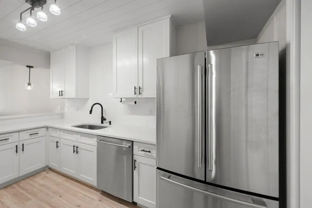a kitchen with a refrigerator sink and cabinets