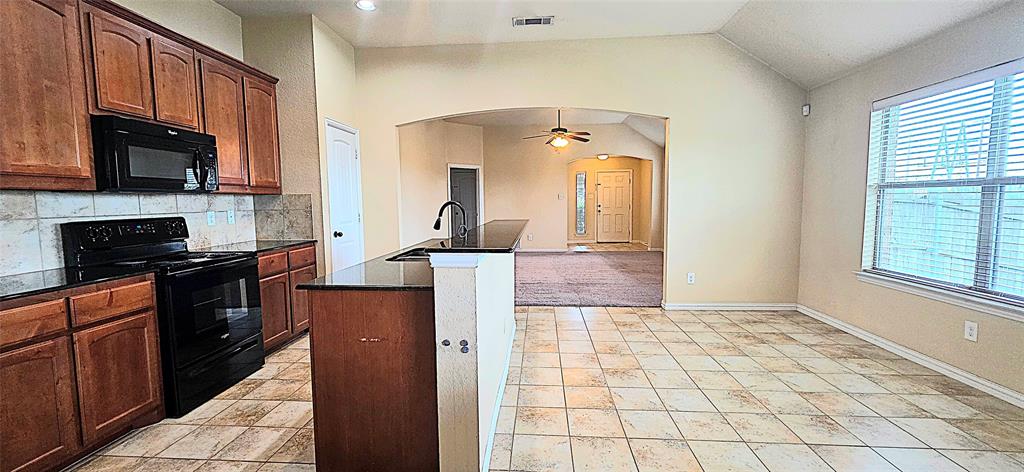 101 Hummingbird Drive Weatherford, TX 76085 - Photo 4 of 10 a kitchen with stainless steel appliances granite countertop a refrigerator a stove top oven and a sink