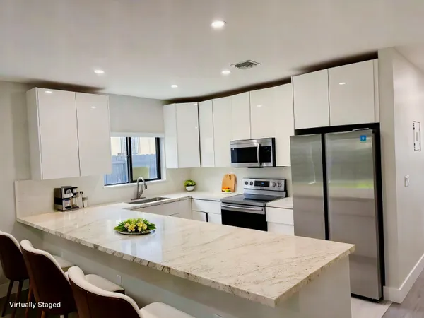 a kitchen with kitchen island refrigerator stove microwave and cabinets