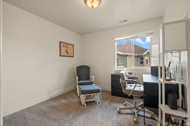 8248 South Resaca Drive, Unit J10 Sandy, UT 84070 - Photo 19 of 40 Bright interior room with a large window, light-colored walls, and gray carpeting