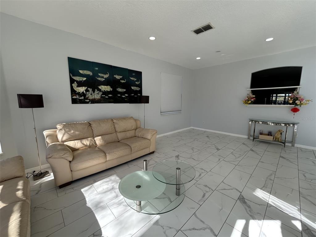 10439 Andover Point Circle Orlando, FL 32825 - Photo 12 of 33 a living room with furniture and a flat screen tv