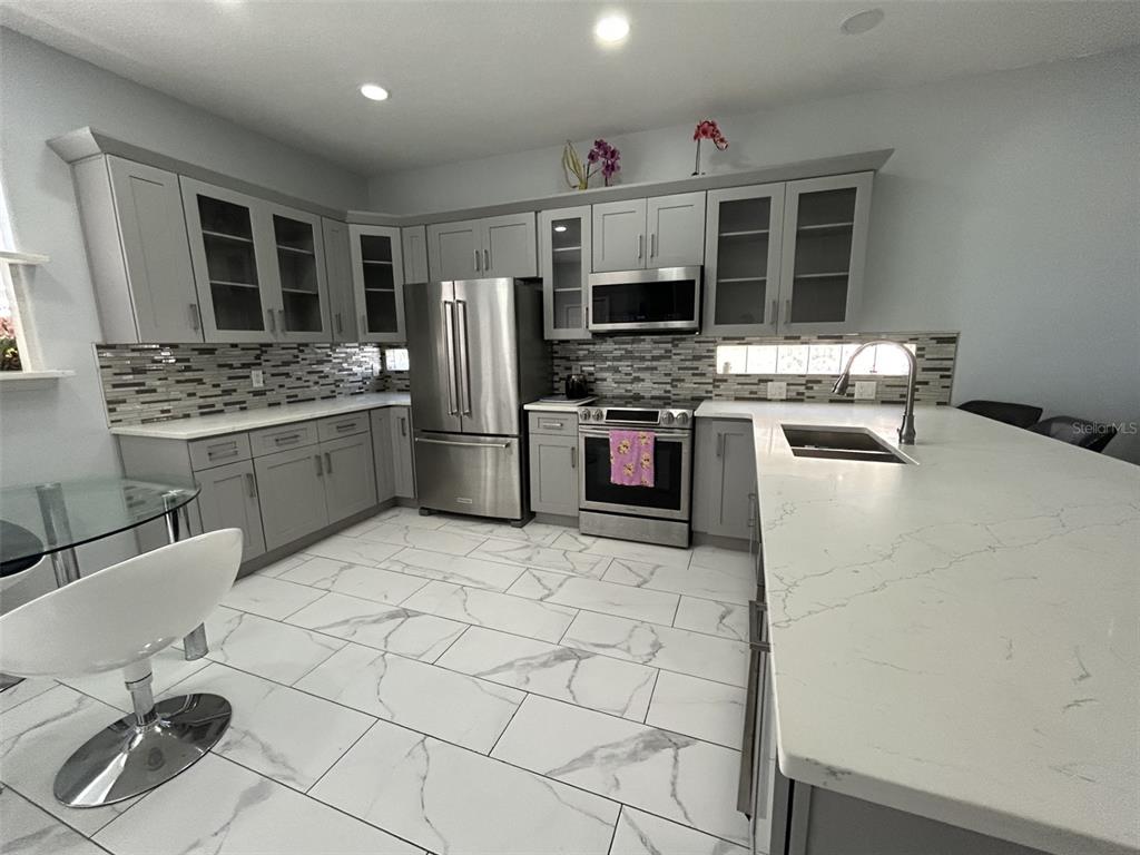 10439 Andover Point Circle Orlando, FL 32825 - Photo 6 of 33 a kitchen with stainless steel appliances granite countertop a stove refrigerator and a sink