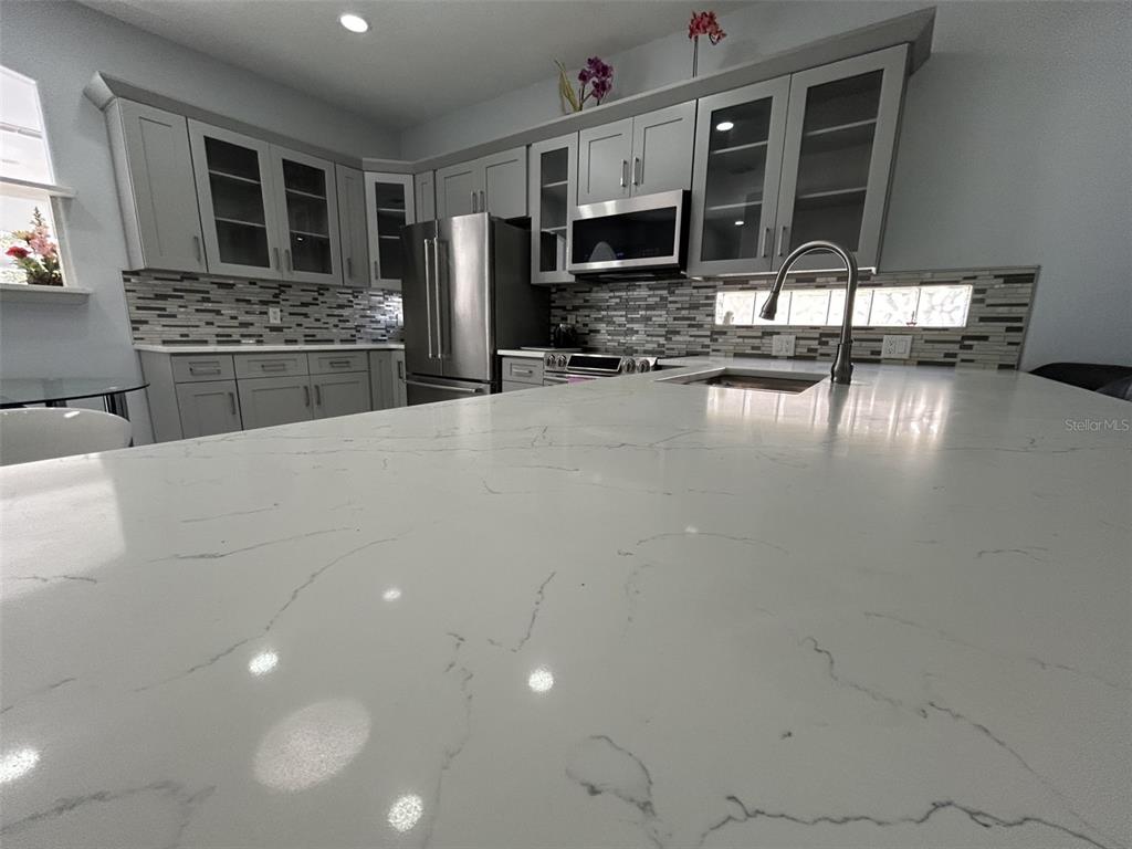 10439 Andover Point Circle Orlando, FL 32825 - Photo 7 of 33 a kitchen with kitchen island granite countertop a stove and a refrigerator