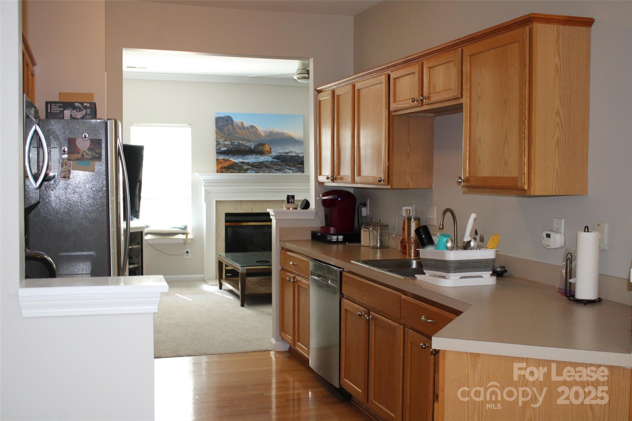 18630 Oakhurst Boulevard Cornelius, NC 28031 - Photo 3 of 20 a kitchen with stainless steel appliances granite countertop a refrigerator a stove and a sink with wooden floor