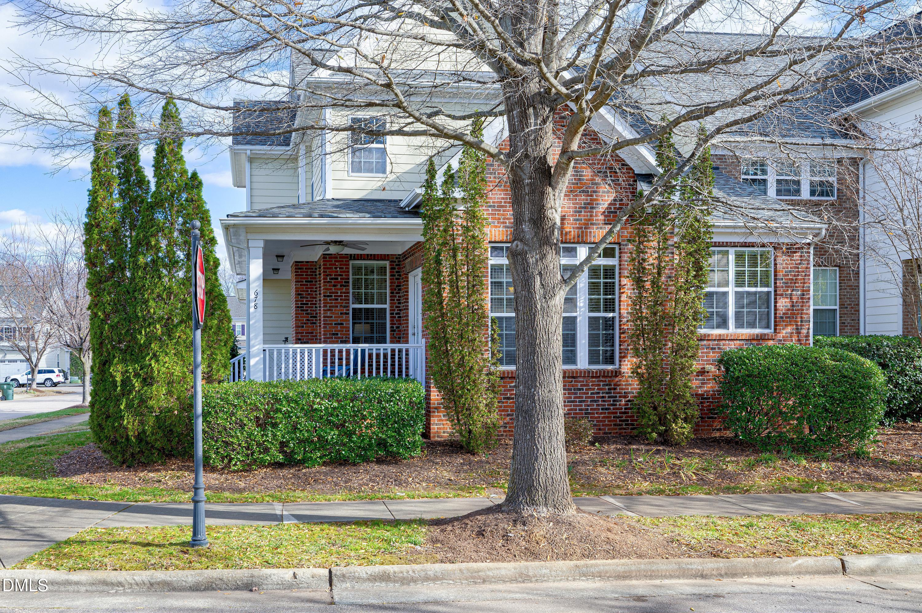 678 Democracy Street Raleigh, NC 27603 - Photo 3 of 67 a view of a brick house with a yard plants and large tree
