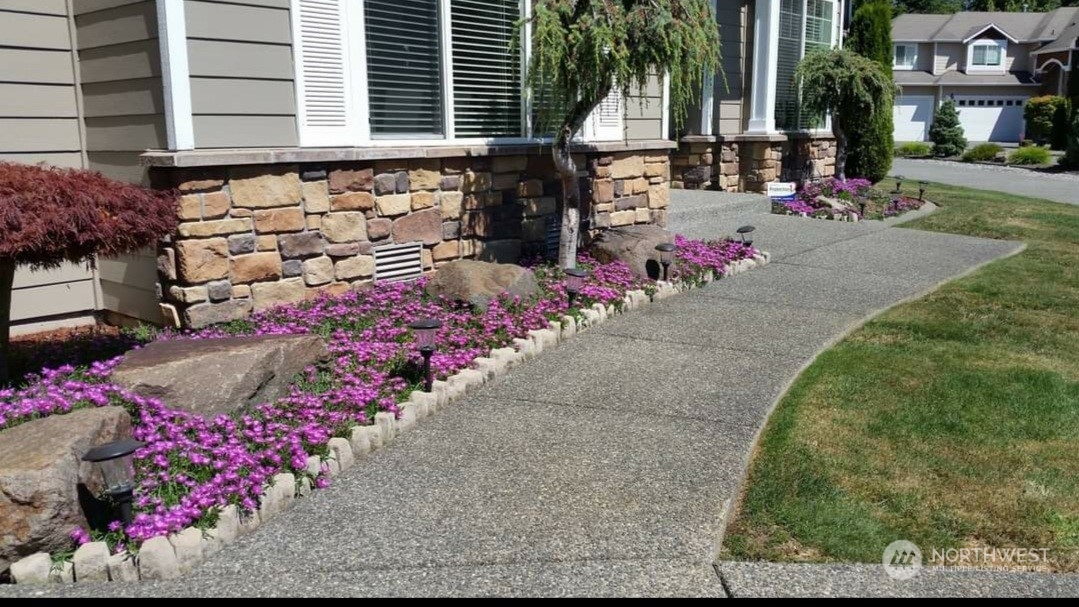 113 181st Street Southwest Bothell, WA 98012 - Photo 23 of 26 a front view of a house with a yard and flowers