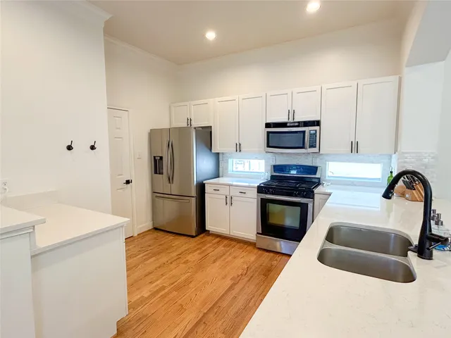 a kitchen with granite countertop a refrigerator stove and sink