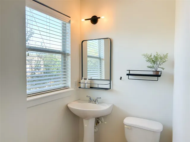 a bathroom with a sink a toilet and a mirror