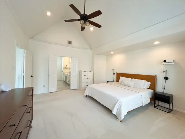 a spacious bedroom with a bed and a chandelier