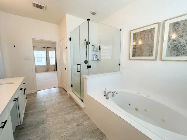 a spacious bathroom with a bathtub and a shower