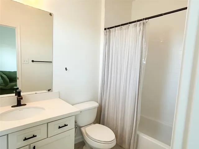 a bathroom with a sink a toilet a mirror and shower