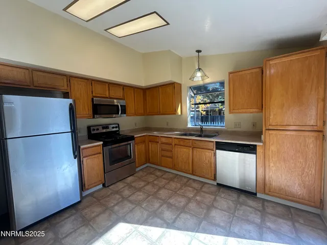 a kitchen with granite countertop stainless steel appliances and refrigerator