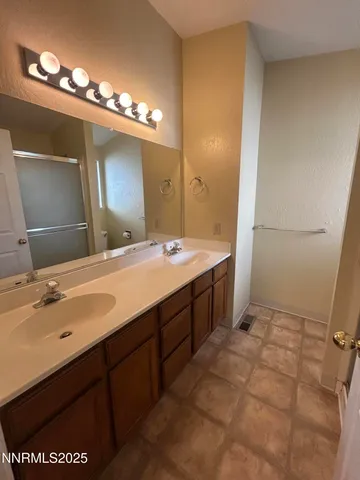 a spacious bathroom with a double vanity sink and a mirror