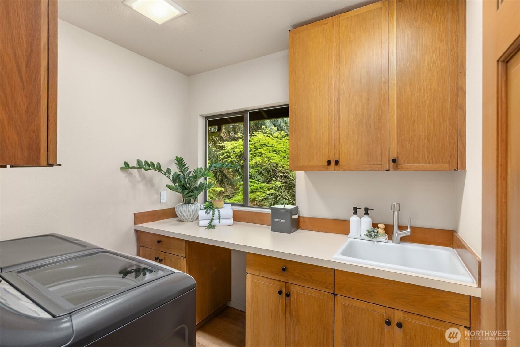 8151 Northeast Hidden Cove Road Bainbridge Island, WA 98110 - Photo 17 of 40 a room with a sink cabinets and wooden floor