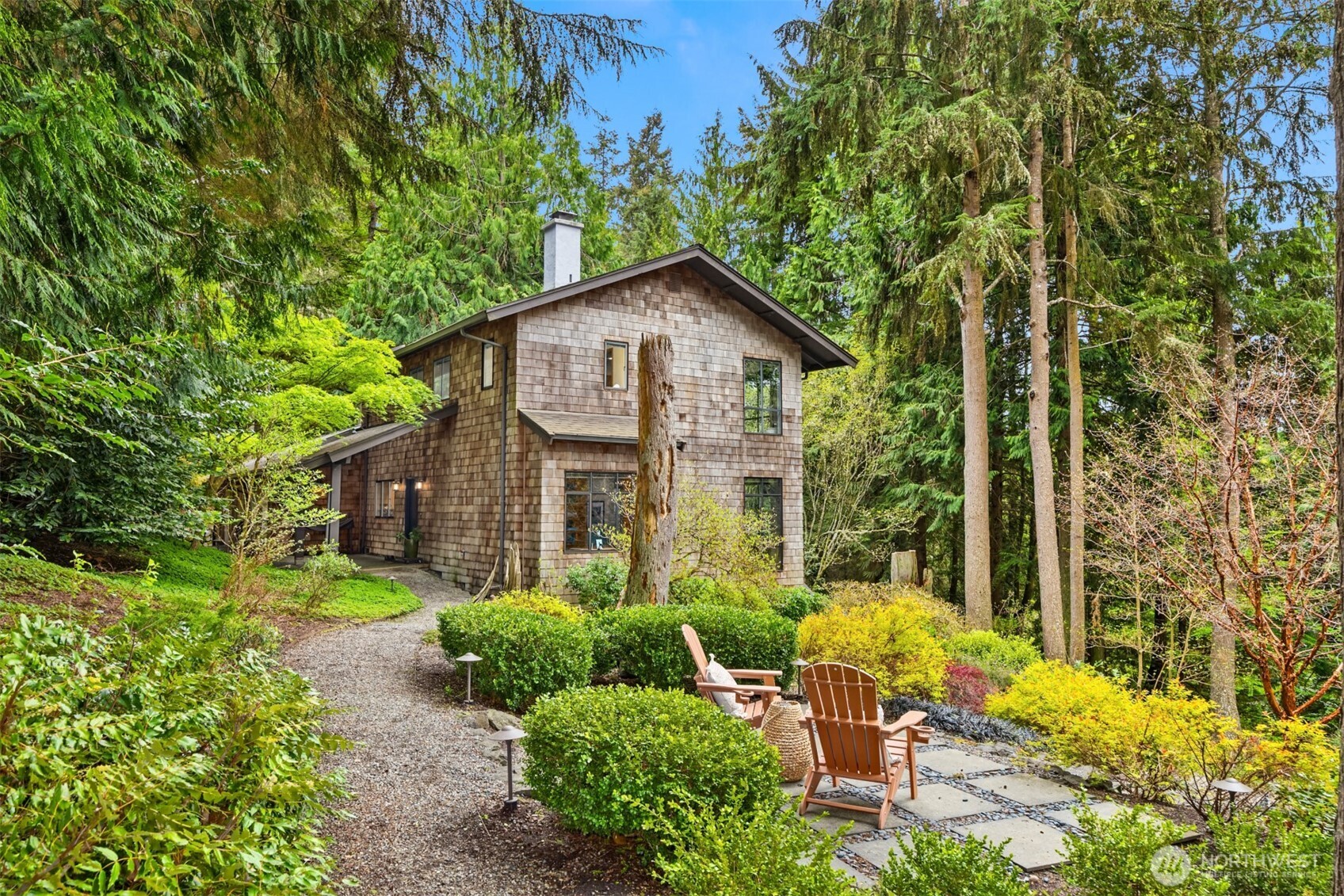 8151 Northeast Hidden Cove Road Bainbridge Island, WA 98110 - Photo 2 of 40 a view of a chair and table in backyard of the house