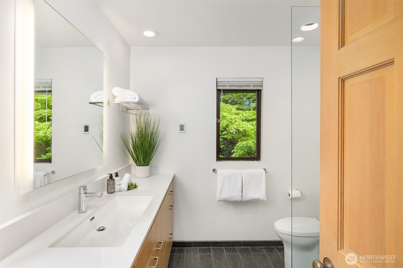 8151 Northeast Hidden Cove Road Bainbridge Island, WA 98110 - Photo 21 of 40 a bathroom with a sink a toilet and a mirror