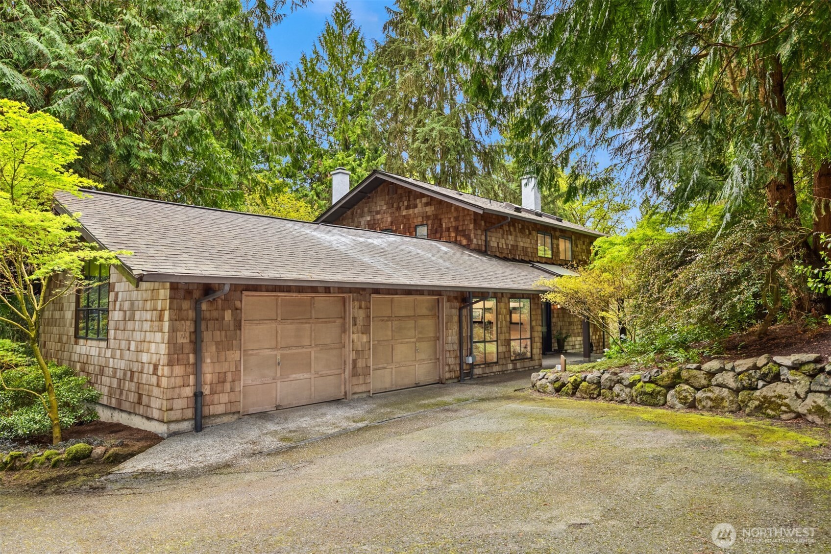 8151 Northeast Hidden Cove Road Bainbridge Island, WA 98110 - Photo 37 of 40 a front view of a house with a yard and garage