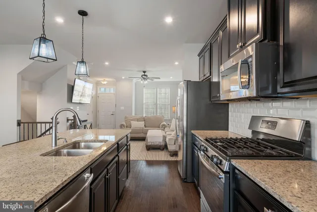 a room with a table chairs a dining table with wooden floor and kitchen view