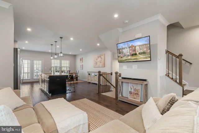 a kitchen with stainless steel appliances kitchen island granite countertop a sink a microwave a refrigerator and chairs