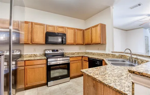 a kitchen with stainless steel appliances granite countertop a sink stove and microwave