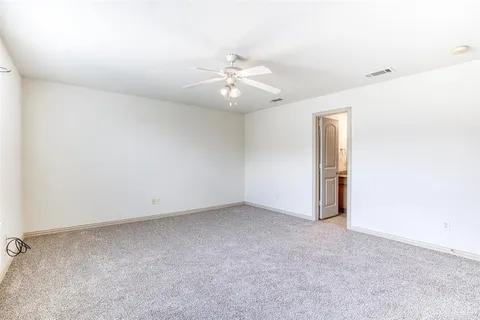 an empty room with chandelier fan and closet