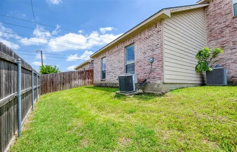 a backyard of a house with plants and wooden fence
