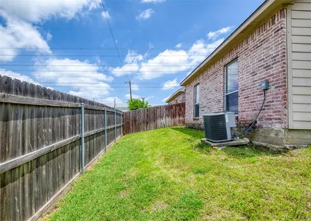 a view of backyard with barbeque grill and wooden fence