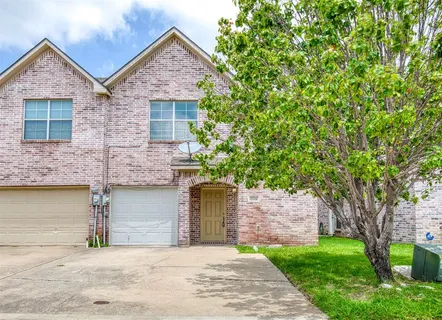 front view of a house with a yard and an trees