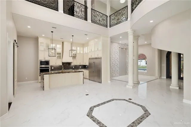 a kitchen with stainless steel appliances kitchen island granite countertop a refrigerator and a sink