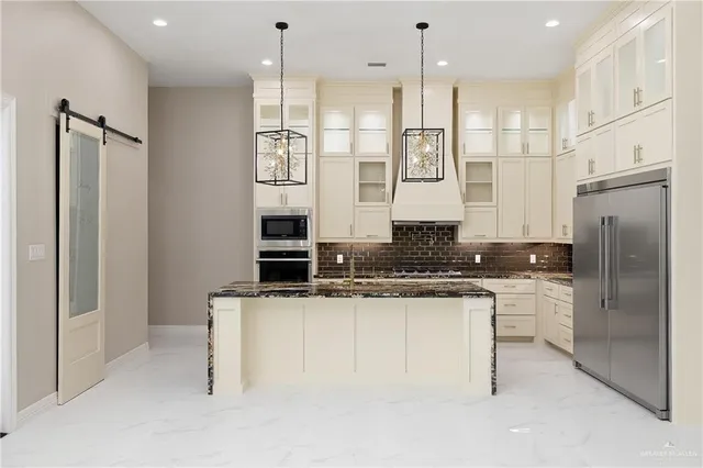 a kitchen with stainless steel appliances granite countertop a refrigerator a sink and a stove