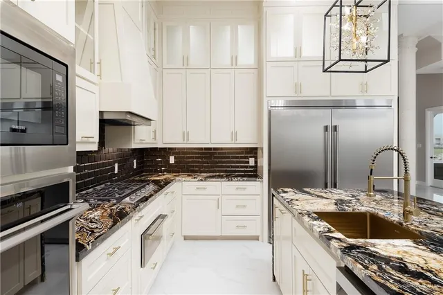 a kitchen with granite countertop a sink stainless steel appliances and cabinets