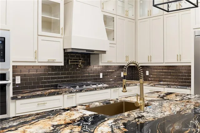 a kitchen with granite countertop a sink and a stove