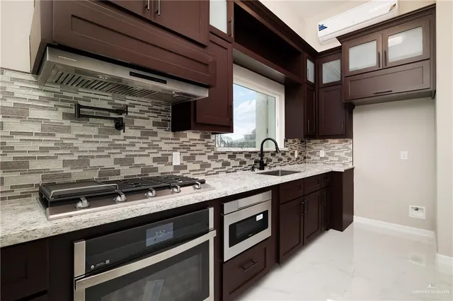 a kitchen with stainless steel appliances a sink stove and cabinets