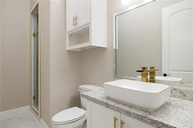 a bathroom with a toilet a sink and mirror